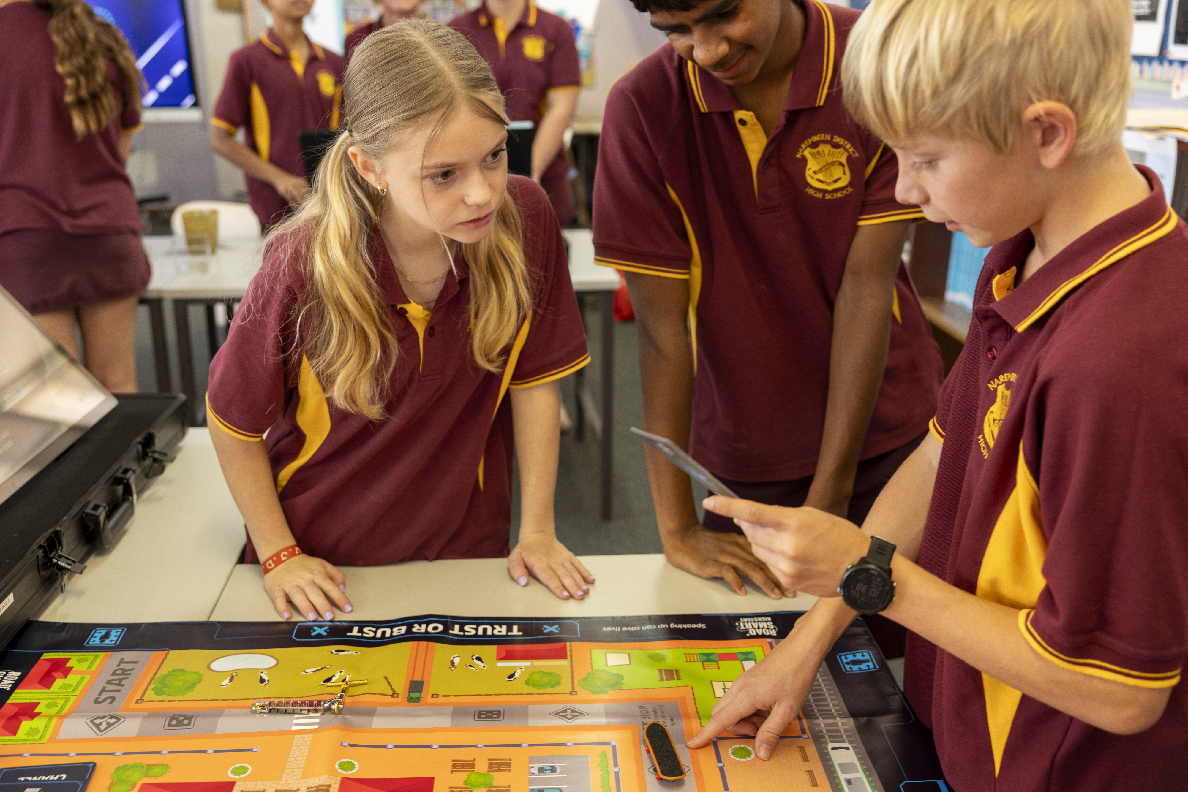 3 students playing the trust or bust board game
