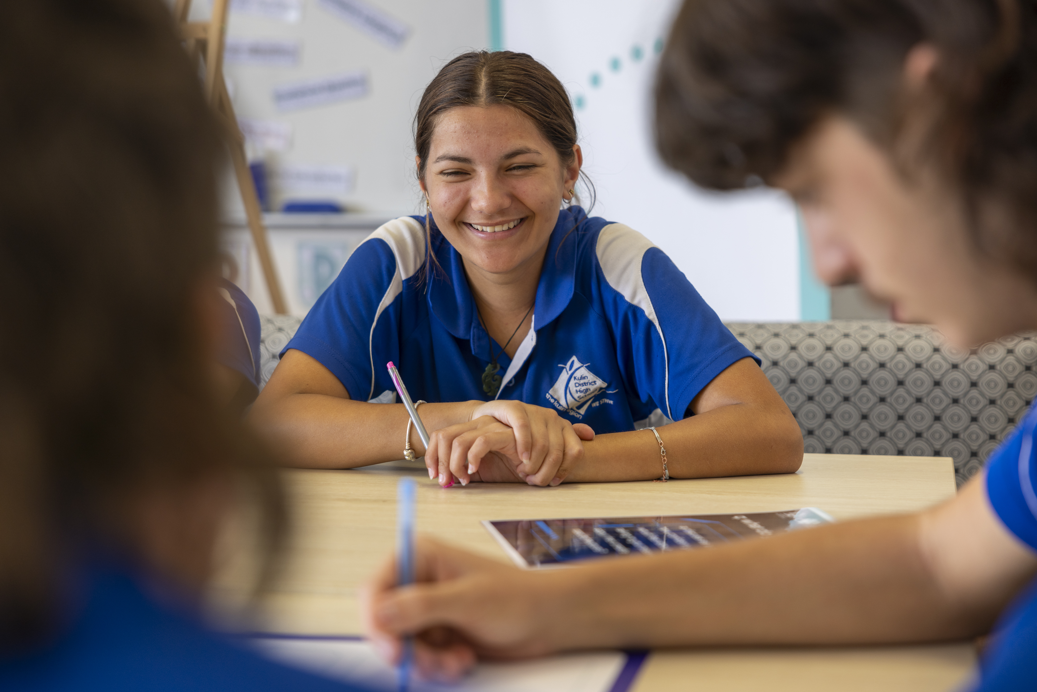 A female student smiling whilst working on mind map